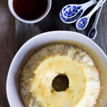 A tall, silky-soft gluten-free Argentinian bread pudding with spoons.