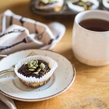 pumpkin muffin on a plate with a cup of tea