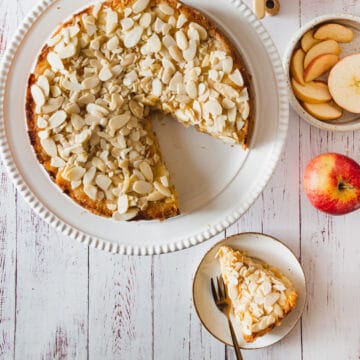 A gluten-free slice of apple cake with almonds on a plate.